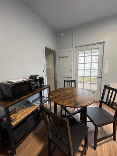 une cuisine avec une table et des chaises et un micro-ondes dans l'établissement La Suite Saphir, à Saint-Aignan
