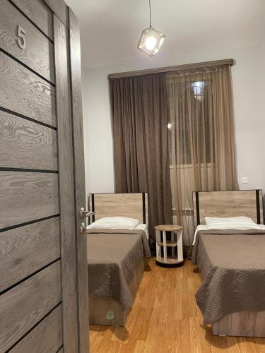 a room with two beds and a sliding door at Hostel Divan in Yerevan