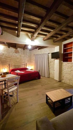 a bedroom with a red bed and a table at Le Dimore dei Ritaldi in Castel Ritaldi