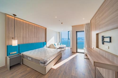 a bedroom with a bed and a chair in it at Căn hộ khách sạn Alacarte Hạ Long in Ha Long