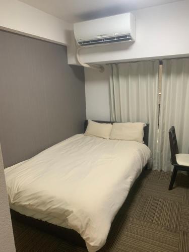 Cama en habitación pequeña con aire acondicionado en STUDIO YONEGAHAMA l 米が浜通, en Yokosuka