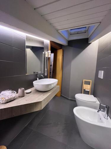 łazienka z 2 umywalkami i toaletą w obiekcie Hotel Veduta dell'Adamello w mieście Temù