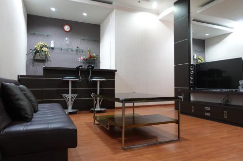 a living room with a black couch and a glass table at Town House MGR 2, Central Park Mall Area, Pool Side-1st floor in Jakarta