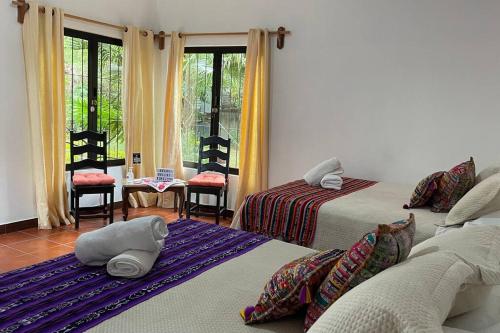 1 dormitorio con 2 camas y 1 dormitorio con ventanas en THE VIEW HOUSE- Antigua Guatemala Toda La Casa, en Antigua Guatemala