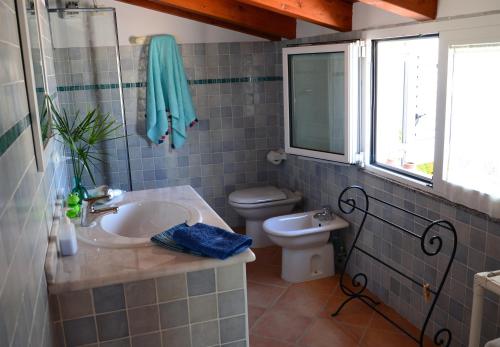 B&B Lloc D'Or في ألغيرو: حمام مع حوض ومرحاض ونافذة