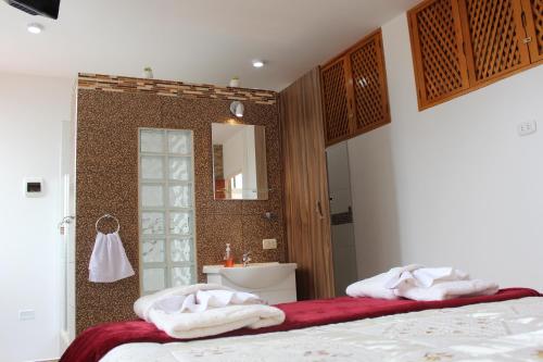 łazienka z 2 ręcznikami na łóżku i umywalką w obiekcie Hosting Home - Casa Bella w mieście Cajamarca