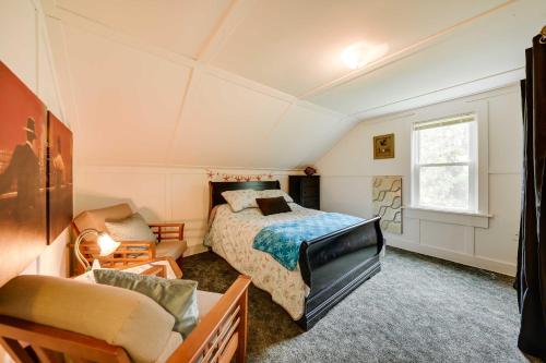 een slaapkamer met een bed, een stoel en een bank bij Powers Lake Home with Patio - 9 Mi to Lake Geneva! in Powers Lake