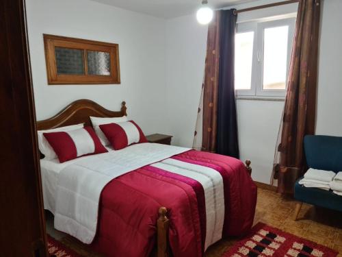 Un dormitorio con una cama roja y blanca y una ventana en Casa Valente, en Macedo de Cavaleiros
