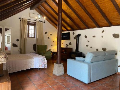 une chambre avec un lit et une chaise dans une pièce dans l'établissement La casa vieja de la Montaña, à Santa Lucía