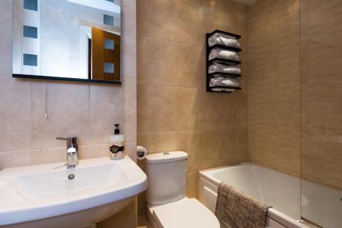 a bathroom with a toilet and a sink and a tub at Stunning Sea View Central Torbay Home with Parking in Torquay