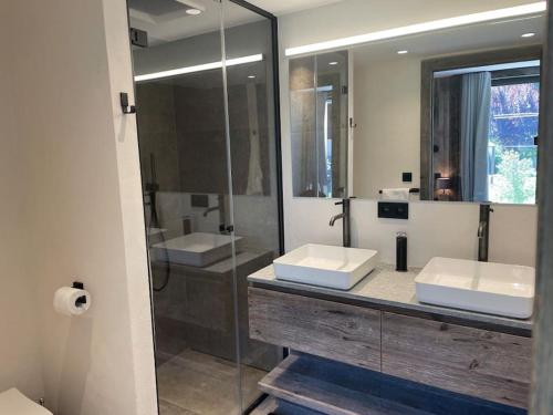 a bathroom with two sinks and a glass shower at Chalet Esquinade 4 bedrooms appartment Megève in Megève