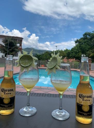 drie glazen bier zittend op een tafel naast een zwembad bij hotel el quijote in La Pintada