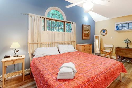 a bedroom with a bed with a red bedspread and a window at Beaconhill Road 68 in Ocean Pines