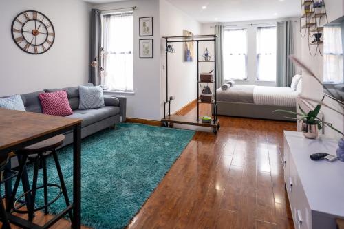 sala de estar con sofá y alfombra verde en REEF7 - Modern central flat, 5 mins from beach, centre and Bournemouth International Centre en Bournemouth