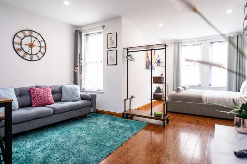 a living room with a couch and a mirror at REEF7 - Modern central flat, 5 mins from beach, centre and Bournemouth International Centre in Bournemouth