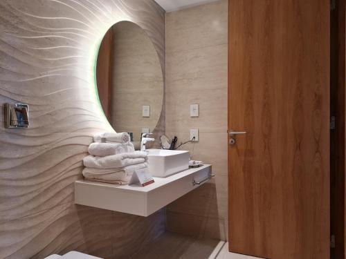 uma casa de banho com um lavatório e um espelho em Del Bono Central Hotel em San Juan
