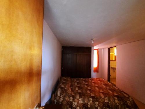 ein kleines Schlafzimmer mit einem Bett in einem Zimmer in der Unterkunft HOSTAL LARA in Arequipa