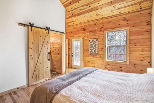 1 dormitorio con paredes de madera y 1 cama en una habitación en Fern Woods A modern take on Hocking Hills cabins, en Stella