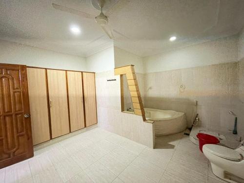 a bathroom with a toilet and a tub and a sink at Karachi Family Guest House in Karachi