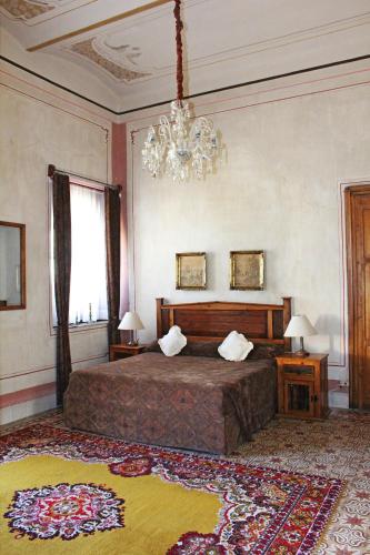a bedroom with a large bed and a chandelier at Hotel Boutique Casa de la Palma in Puebla