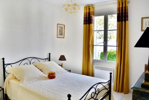 - une chambre avec un lit doté de rideaux jaunes et d'une fenêtre dans l'établissement Ravissante Villa en bord de plage aux Grenettes, à Sainte-Marie de Ré