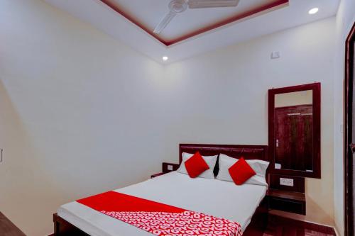 a bedroom with a bed with red and white pillows at Flagship Hotel Days Inn in Rānchī