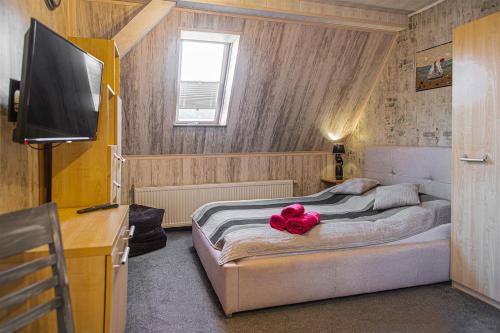 a bedroom with a bed with a pink stuffed animal on it at PROMYK - Apartamenty & Pokoje - dla dorosłych in Białogóra