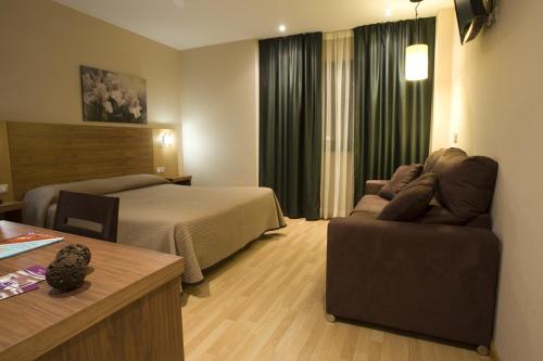 une chambre d'hôtel avec un lit et un canapé dans l'établissement Hotel Mar de Plata, à Sarria
