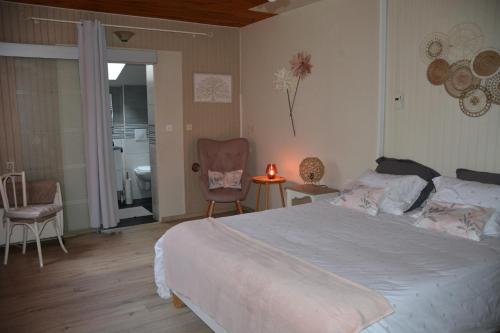 1 dormitorio con 1 cama grande y baño en LE HOME FLEURI MLD en Ménesplet