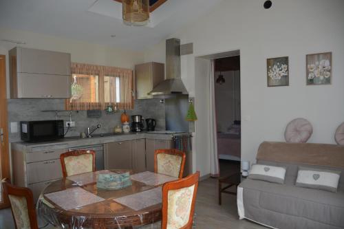 - une cuisine et une salle à manger avec une table et un canapé dans l'établissement LE HOME FLEURI MLD, à Ménesplet