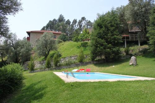 una piscina en un patio con una casa al fondo en Casas do Corvo en Ventosa