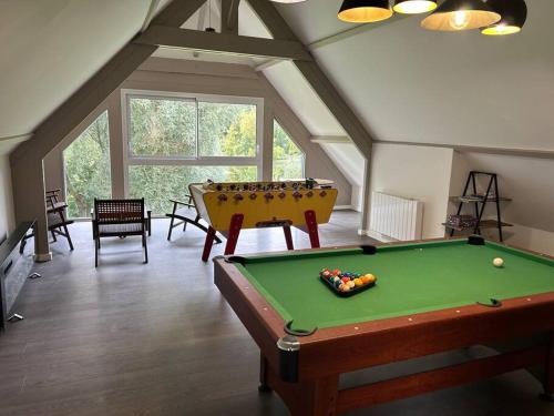 Cette chambre mansardée dispose d'un billard. dans l'établissement La Héronnière - gîte de groupe, à Houlle