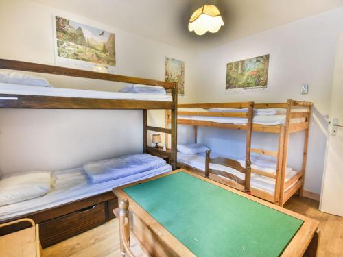 une chambre avec trois lits superposés et une table dans l'établissement Superbe T3 avec Grande Terrasse - 6 Pers, Proche Centre des Gets - FR-1-685-11, aux Gets