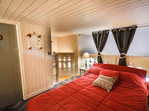 - une chambre avec un lit rouge et un oreiller dans l'établissement Charmant T2 avec mezzanine près des pistes et du centre des Gets - 5 pers., balcon, parking, wifi - FR-1-685-72, aux Gets
