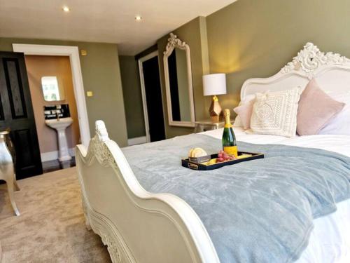 una camera con un letto bianco e una bottiglia di champagne di The Hamilton Luxury Let-The Duke a Scorton