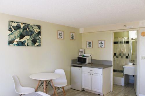 a small kitchen with a table and a microwave at Hawaiian Monarch 1915 condo in Honolulu