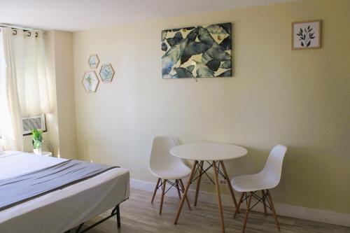 a bedroom with a bed and a table and chairs at Hawaiian Monarch 1915 condo in Honolulu