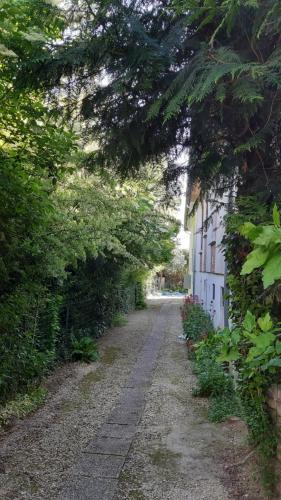 una strada vuota accanto a una casa bianca con alberi di 1 Chambre double "Le Devenir" a Saint-Julien-les-Villas