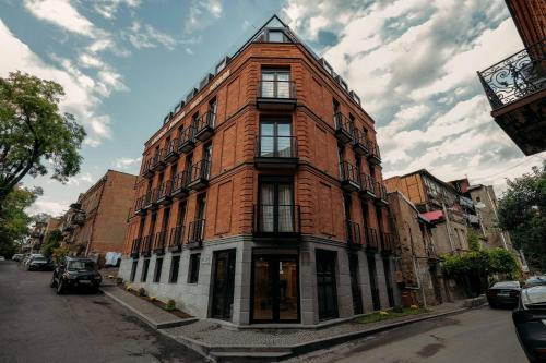 a tall red brick building on a city street at Atrium Boutique Hotel in Tbilisi City