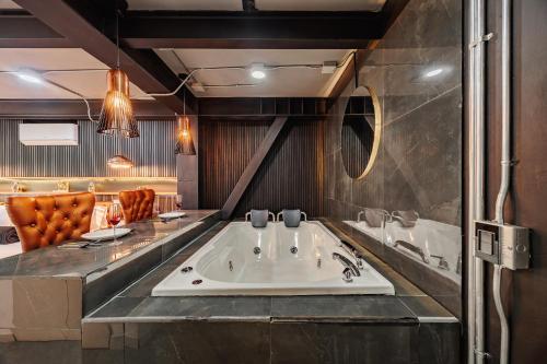 a bathroom with a bath tub and a sink at Hotel One Laureles in Medellín