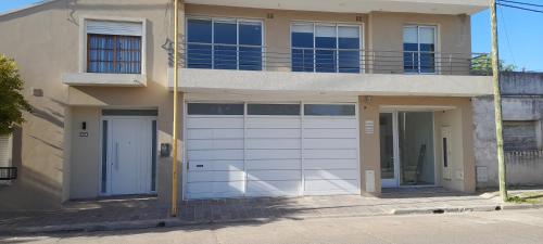 a house with white garage doors and a balcony at El mejor lugar in Gualeguaychú
