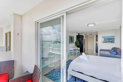 a hotel room with a bed and a balcony at Waterfront Studio Condo in the Heart of Miami - Free Parking & Bay Views in Miami Beach