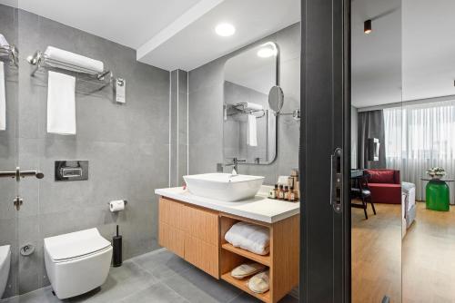 La salle de bains est pourvue d'un lavabo et de toilettes. dans l'établissement Ibos Hotels Izmir Alsancak, à Alsancak