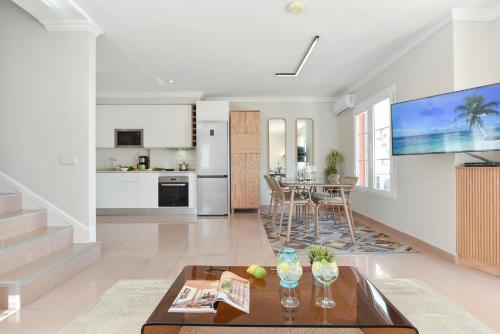 a living room with a table and a kitchen at Chalet Santa Ana 15 by VillaGranCanaria in Playa del Ingles