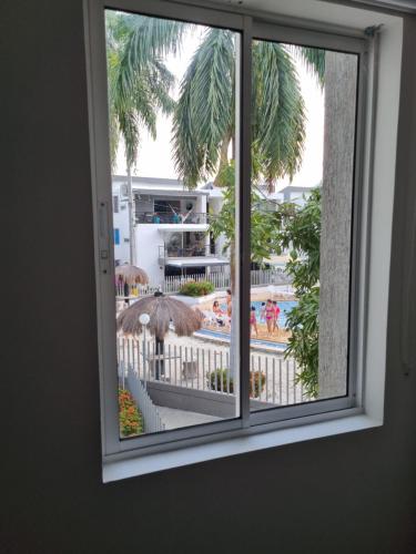 a window with a view of a pool and a resort at Apartasol Ciudadela Santafe in Santa Fe de Antioquia