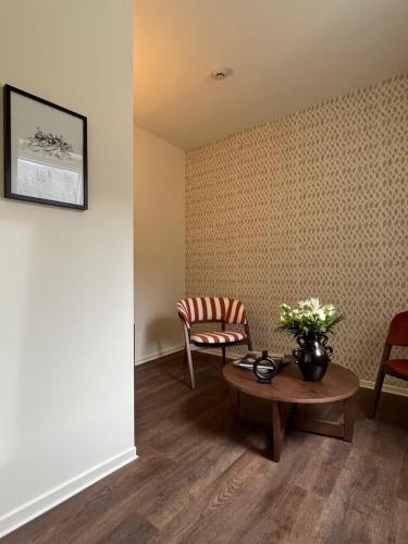 a living room with a table and a chair at Hôtel La Truffe Noire in Brive-la-Gaillarde