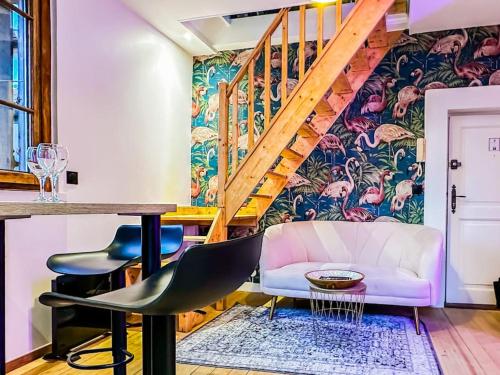 a living room with a staircase and a table and chairs at Flamant Rose in Annecy