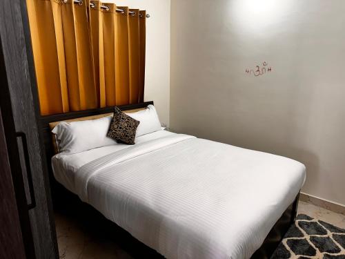 a bedroom with a bed with a wooden headboard at DEEYA Guest House - A Luxury Home Stay in Mysore