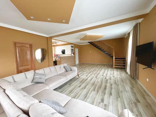 sala de estar con sofá blanco y escalera en Holiday Inn Tianeti, en Tiflis