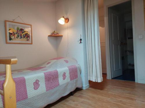 - une chambre dotée d'un lit avec une couverture rose et blanche dans l'établissement Bel appartement rénové avec vue sur le Mont-Blanc, parking couvert, animaux admis - FR-1-517-51, à Chamonix-Mont-Blanc